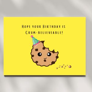 Bright yellow birthday card with cartoon cookie and party hat, reads "Hope your Birthday is Crum-believeable"