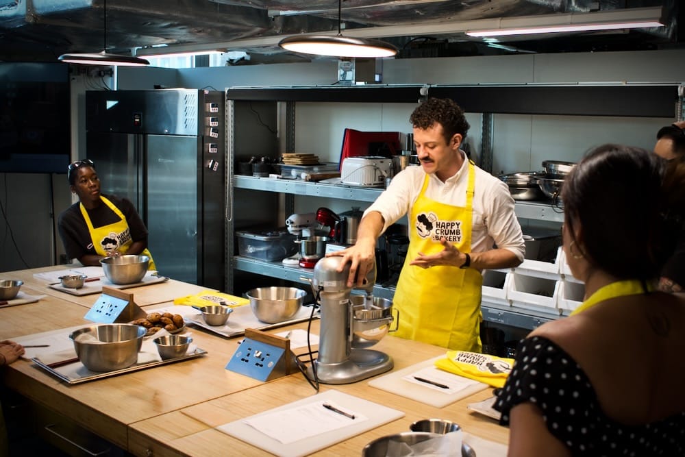 Cookie Lab Team Building Demonstration, London Participants watching a professional cookie baking demonstration at Happy Crumb Bakery's Cookie Lab in London.