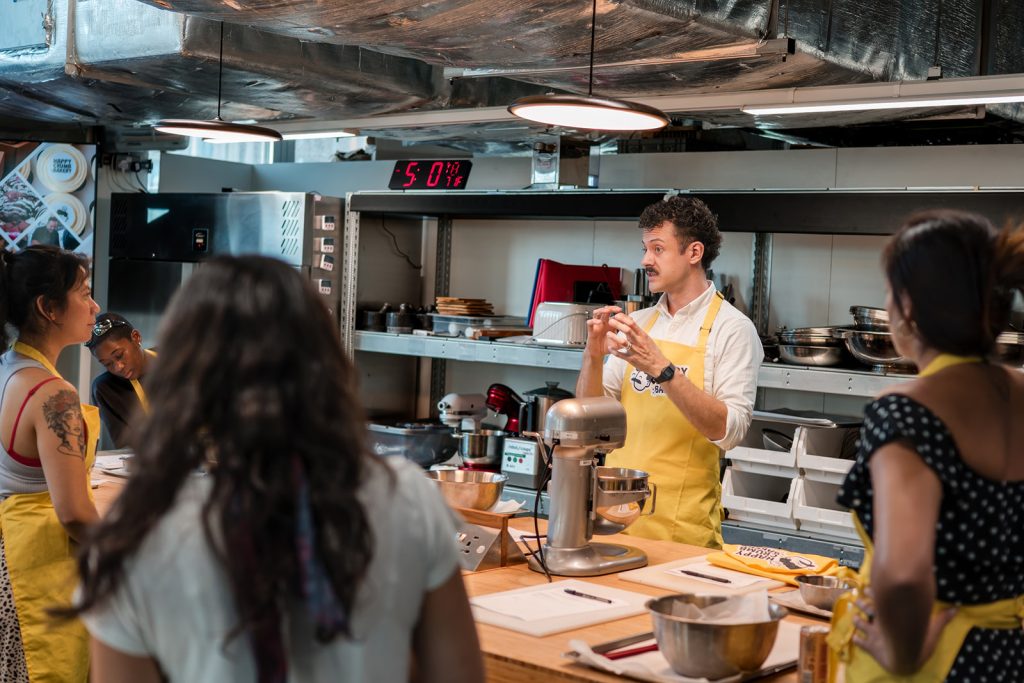 Professional baker demonstrating cookie dough during a corporate away day in London