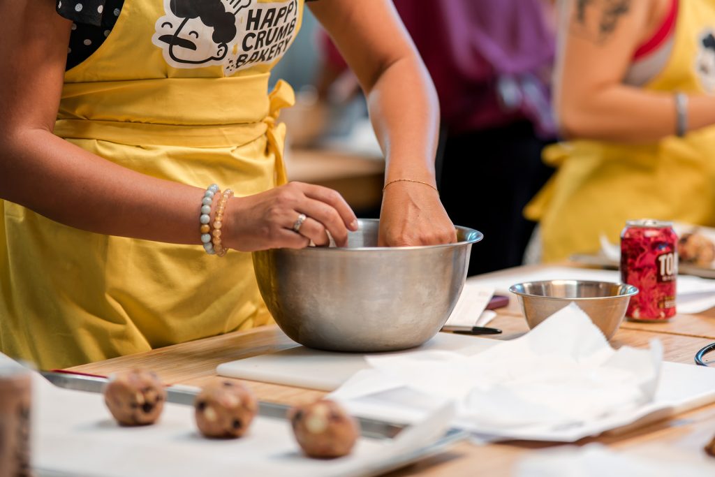 Corporate participants mixing and portioning cookie dough during a London baking workshop